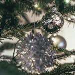 Close-up of shiny Christmas baubles on a decorated fir tree, capturing a festive holiday mood.